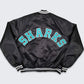 Back of NHL San Jose Sharks satin varsity jacket in black colour featuring large team logo and striped ribbed hem